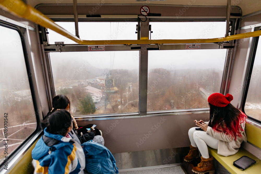 Fototapeta premium Tourists sit in Usuzan Ropeway for going down from Mount Usu in winter in Hokkaido, Japan.