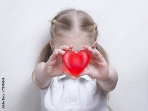 The child shows a red heart. The concept of health and medicine, funds for sick children