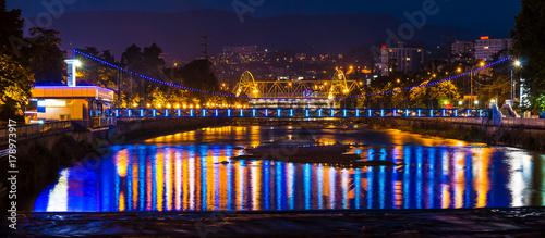 Night panoramic view of illuminated Malyy Kubanskiy bridge, Sochinskiy bridge and Sochi river with lights reflected in its water, Sochi, Russia
