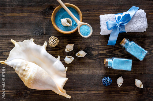 spa cosmetic set with sea salt for bath and shell on wooden background top view