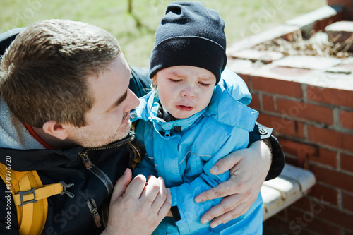 Fotografie Little boy crying on the street. The father and the son.
