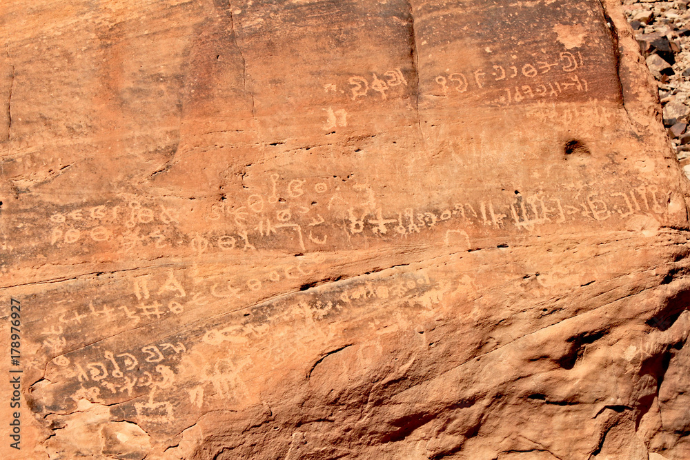 Inscription on red rocks in the valley on Wadi Rum desert in Jordan