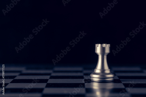 Fototapeta Chess on a chessboard at black background, Business leader concept