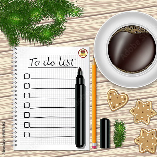 Notebook with to do list, fir tree branches, cookie, a pencil, a marker, and coffee cup on a table with wooden texture.