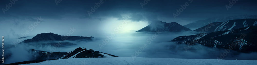Fantasy photo of a mountains in the mist at evening. White lights. Magic and scenic landscape photo