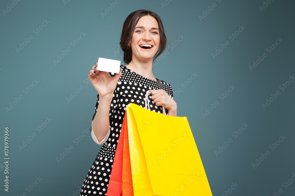 Image of good looking woman in speckled clothes standing with purchases and cutaway in hands