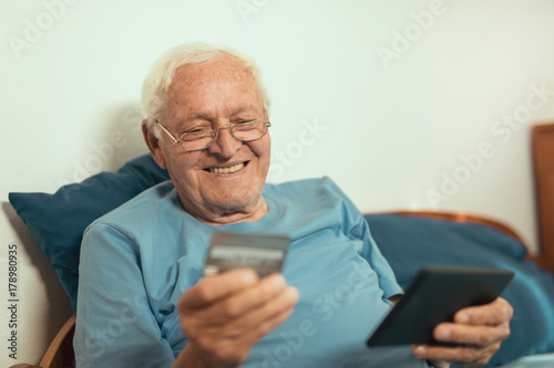 Wallpaper Mural Senior man with credit card for online banking or shopping Torontodigital.ca