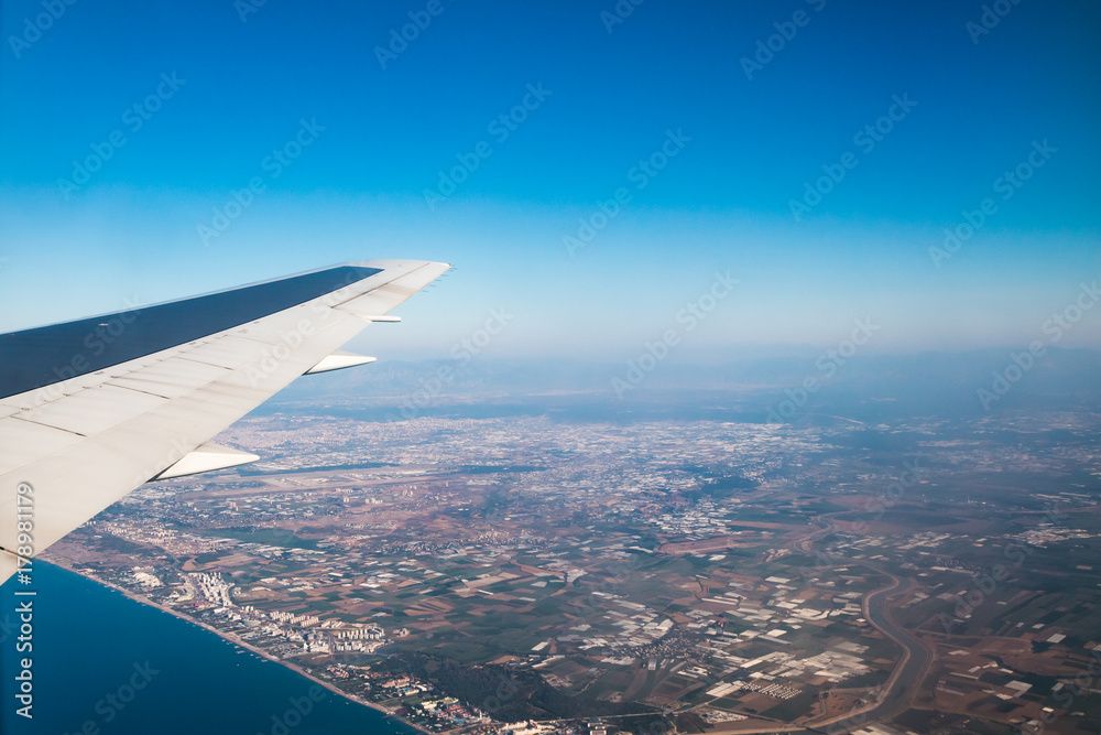 Obraz premium Wing of airplane flying above the Earth