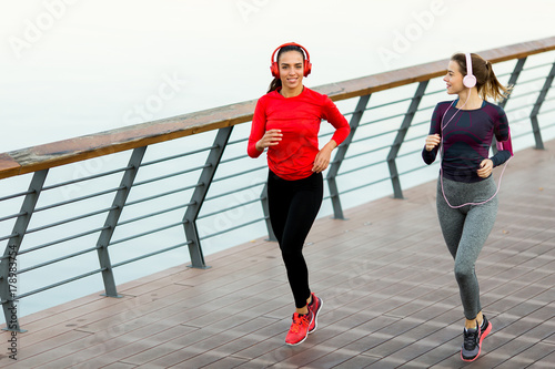 Young women running by the river in the morning