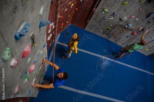 View of athletes examining climbing wall in health club