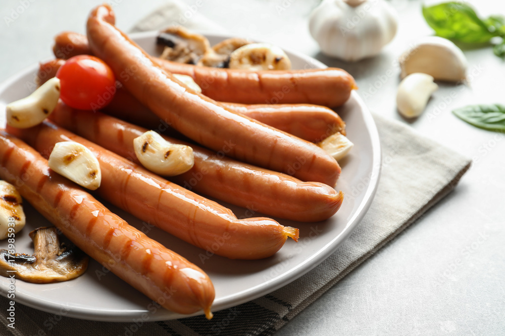 Grilled sausages served with garlic on plate Grilled sausages served with garlic on plate
