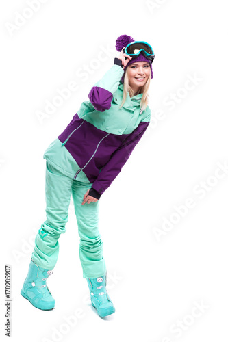 young beautiful woman in purple ski suit and blue snow boots