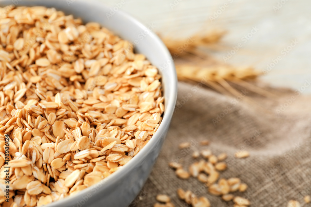 Bowl with raw oatmeal on table, closeup Bowl with raw oatmeal on table, closeup