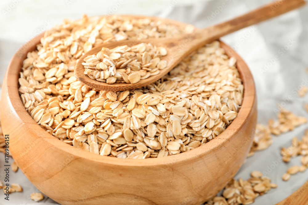 Bowl with raw oatmeal on table, closeup Bowl with raw oatmeal on table, closeup