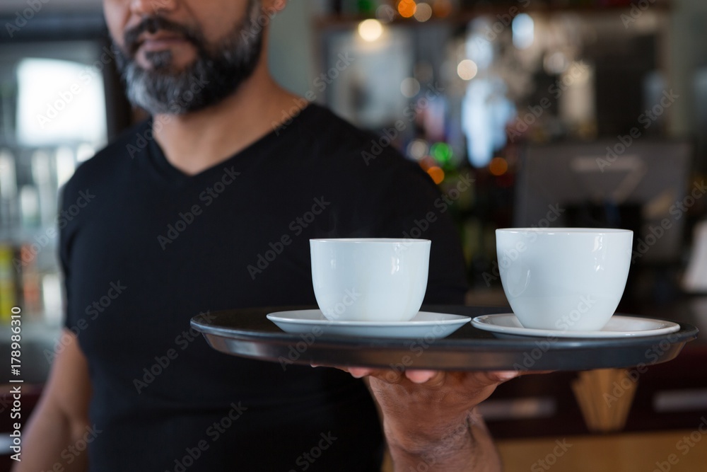 Waiter holding coffee cup