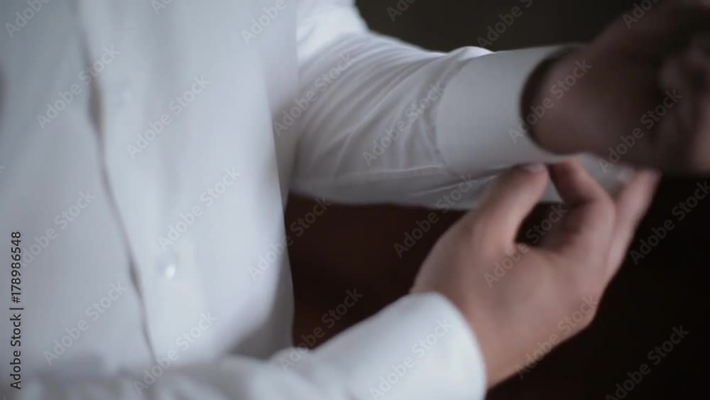 businessman getting ready for a meeting and buttoning up shirt sleeves businessman getting ready for a meeting and buttoning up shirt sleeves