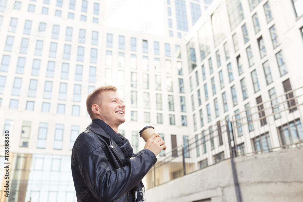 Young hipster man on the street drinking coffee on a sunny day Young hipster man on the street drinking coffee on a sunny day