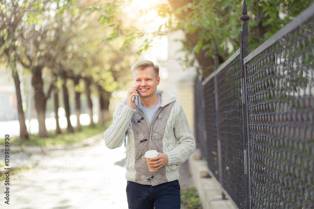 Outdoor portrait of modern young man talking with mobile phone in the city street Outdoor portrait of modern young man talking with mobile phone in the city street