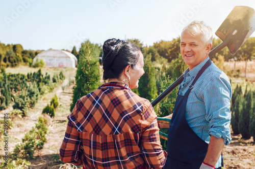 Photo of happy senior couple gardening, wearing professional outfit. 