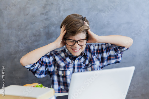 Angry teenage boy working o...