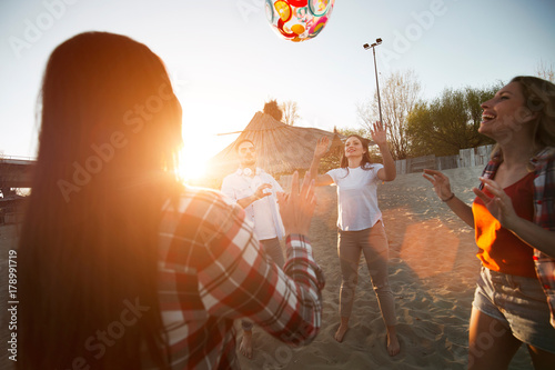 Group of young cheerful friends playing with ball © NDABCREATIVITY