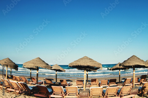 Fototapeta Naklejka Na Ścianę i Meble -  beach umbrellas and sun loungers on the sand near the sea