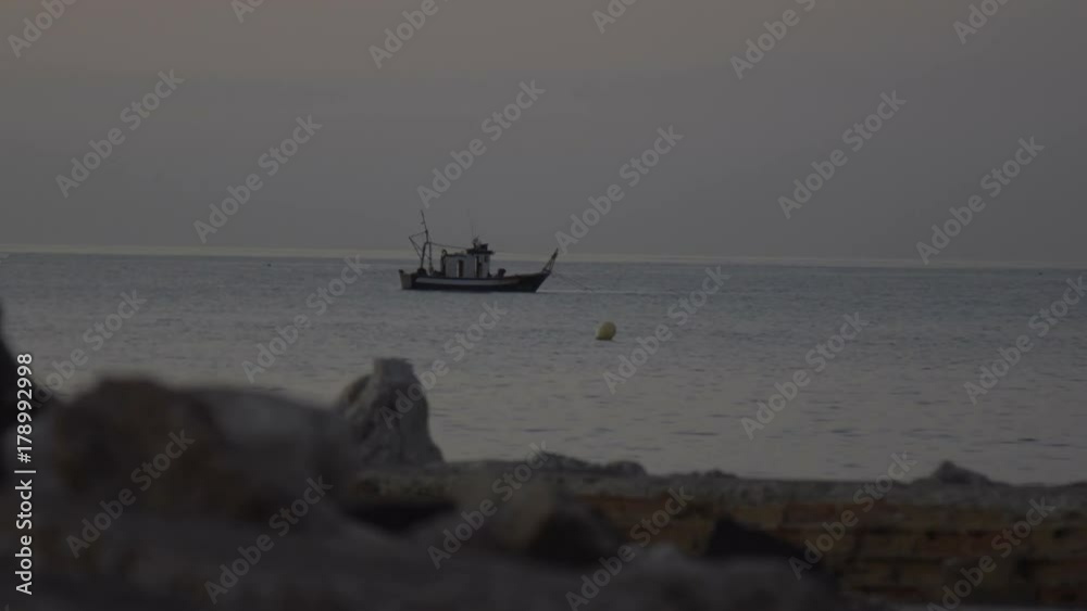 Old fishing boat in ocean at dawn Old fishing boat in ocean at dawn