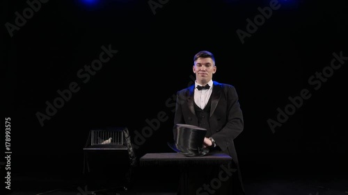 A man dressed as a magician pulling a rabbit from his hat