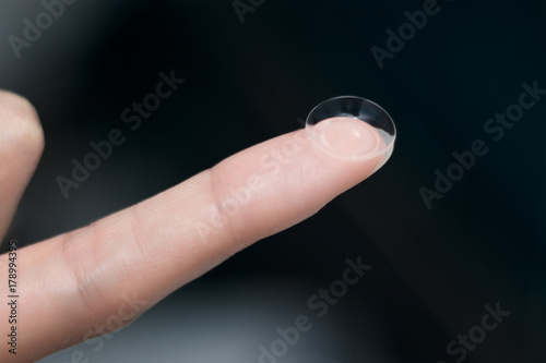 girl holds finger on a contact lens  closeup
