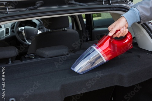 Auto service staff cleaning car with portable vacuum © WavebreakMediaMicro