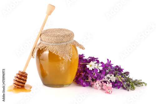 Jar of honey with wildflowers isolated on white background