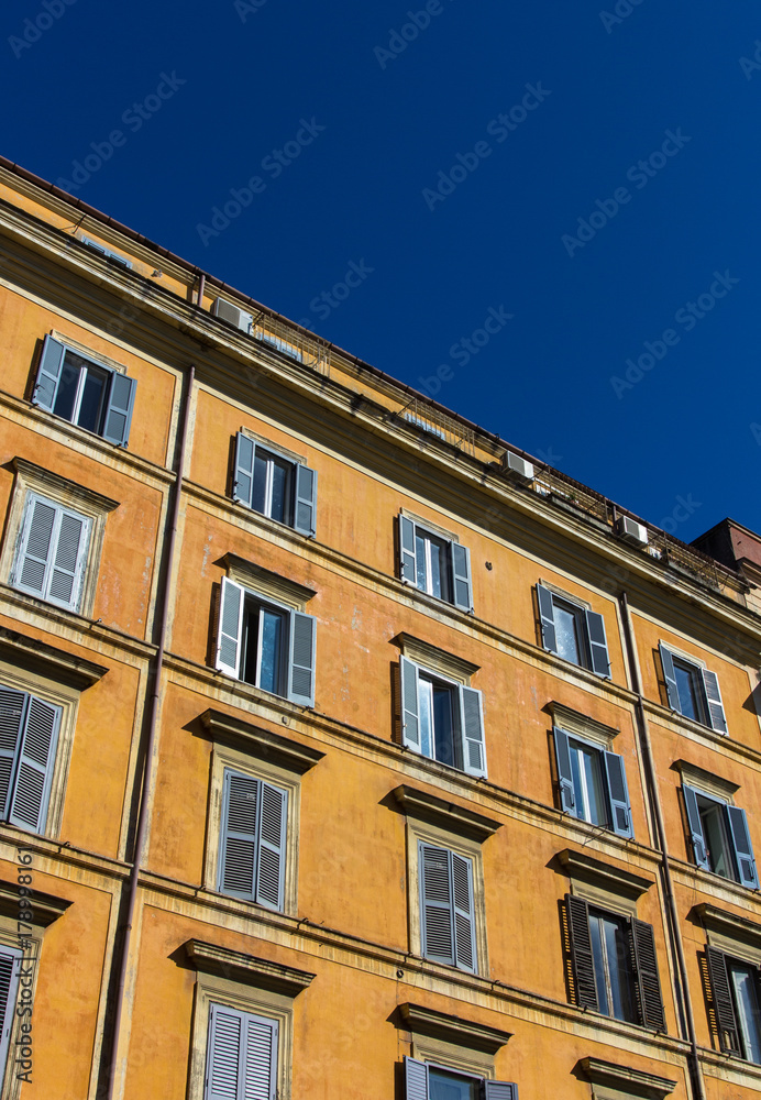 Windows with shutters on the yellow wall