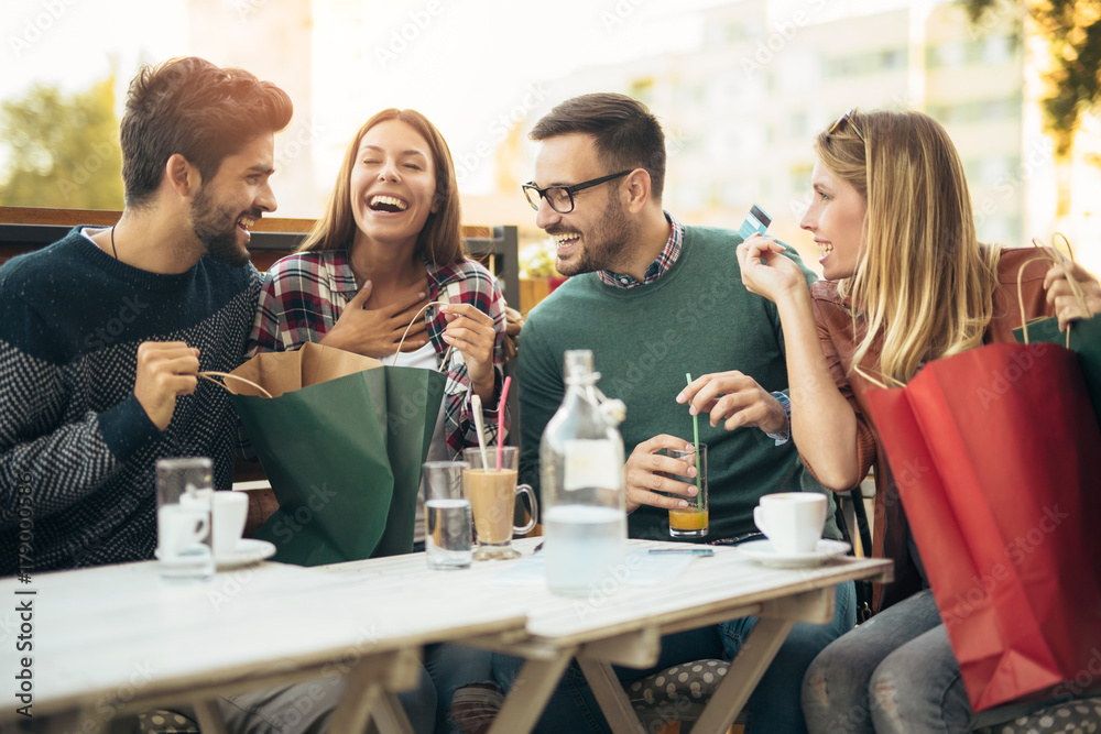 Group of four friends having fun a coffee together after shopping Group of four friends having fun a coffee together after shopping