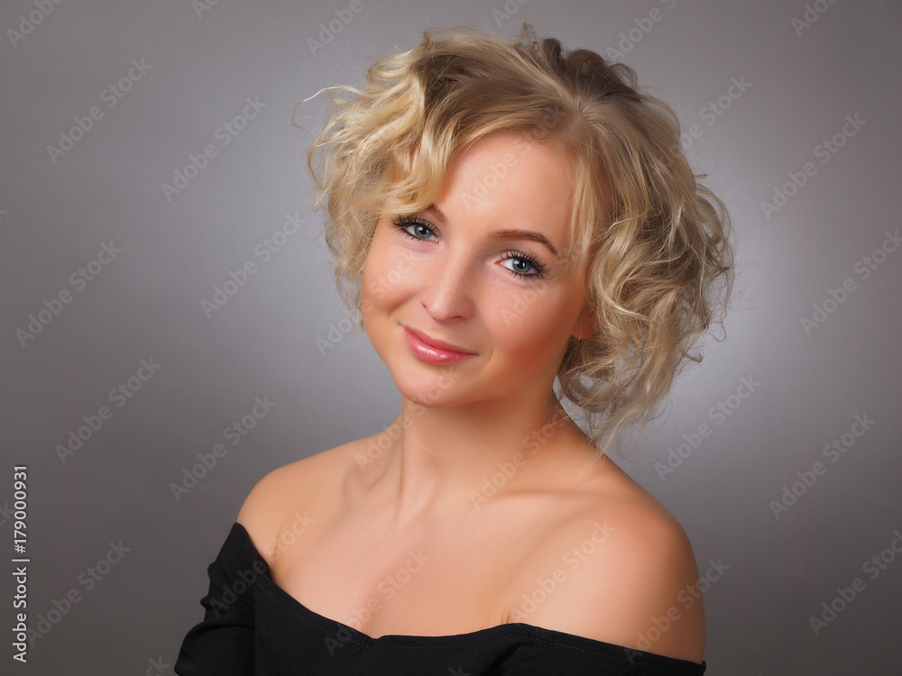 beautiful girl in a black dress on a gray background