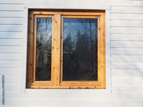 wooden window on white siding background