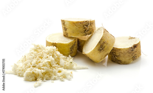 Freshly grated mash of horseradish root and sliced circles isolated on white background