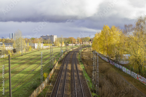 Railway of train depot alongside city buildings and autumn colors