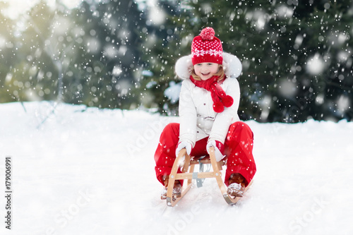 Child sledding. Kid with sledge. Winter snow fun. © famveldman
