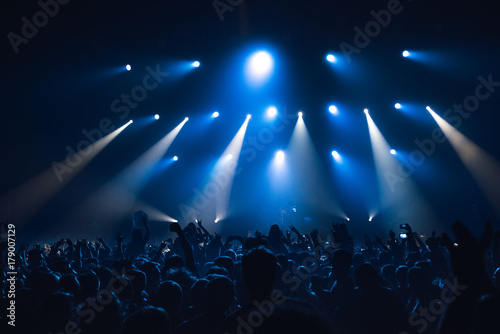 silhouettes of concert crowd in front of bright stage lights