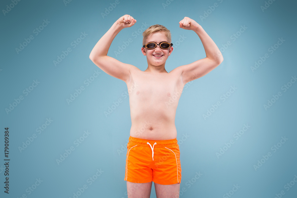 Teenage boy in orange shorts and swimming glasses