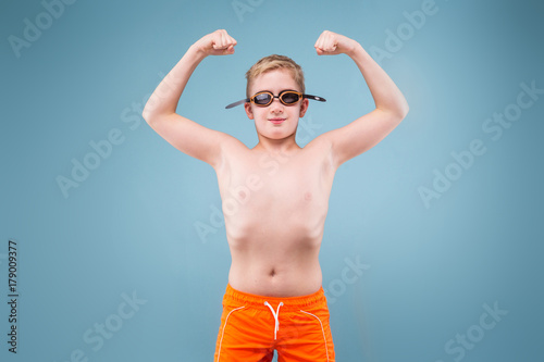 Teenage boy in orange shorts and swimming glasses