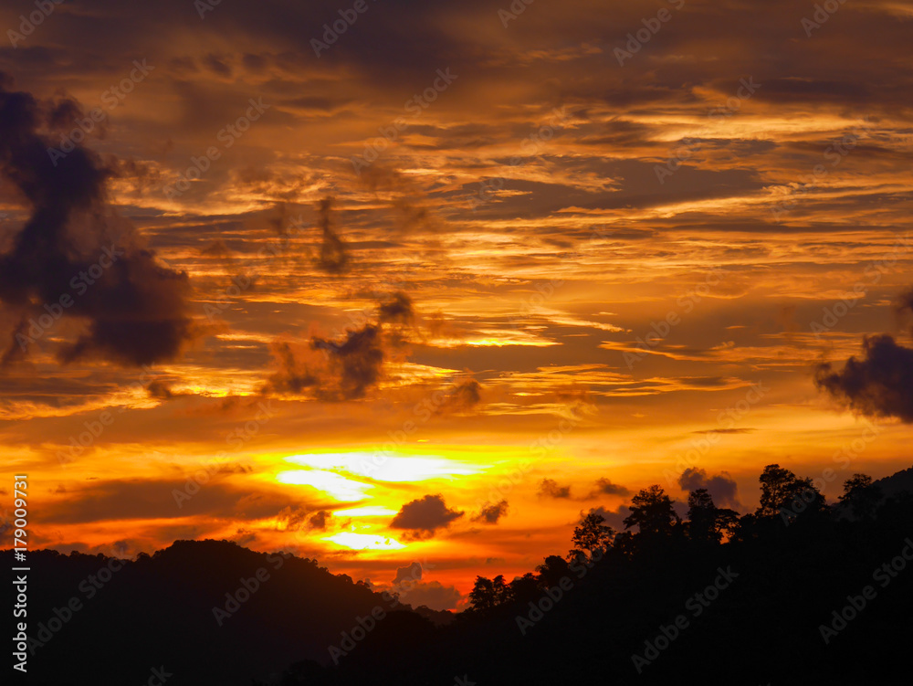 Twilight beautiful evening cloudy sky  after sunset background . There are silhouette mountains and trees.