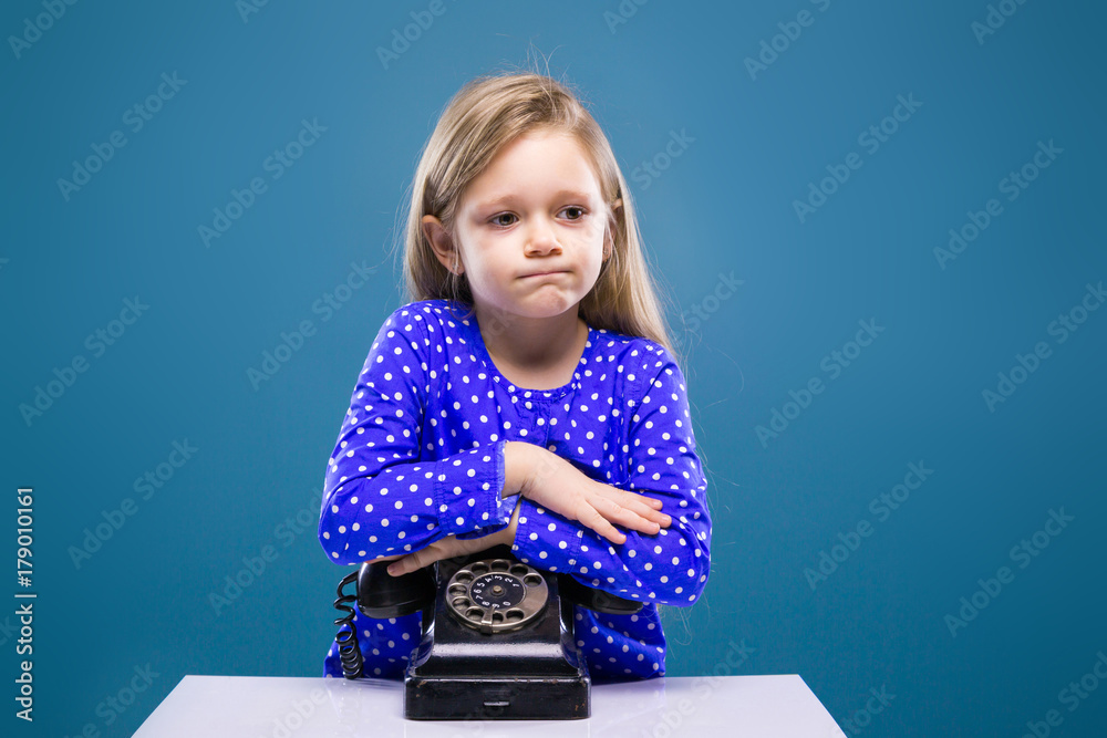 Adorable little girl in purple dress relies on phone Adorable little girl in purple dress relies on phone
