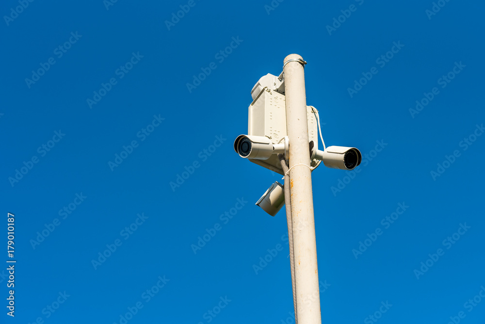 surveillance camera on a pole against the sky surveillance camera on a pole against the sky