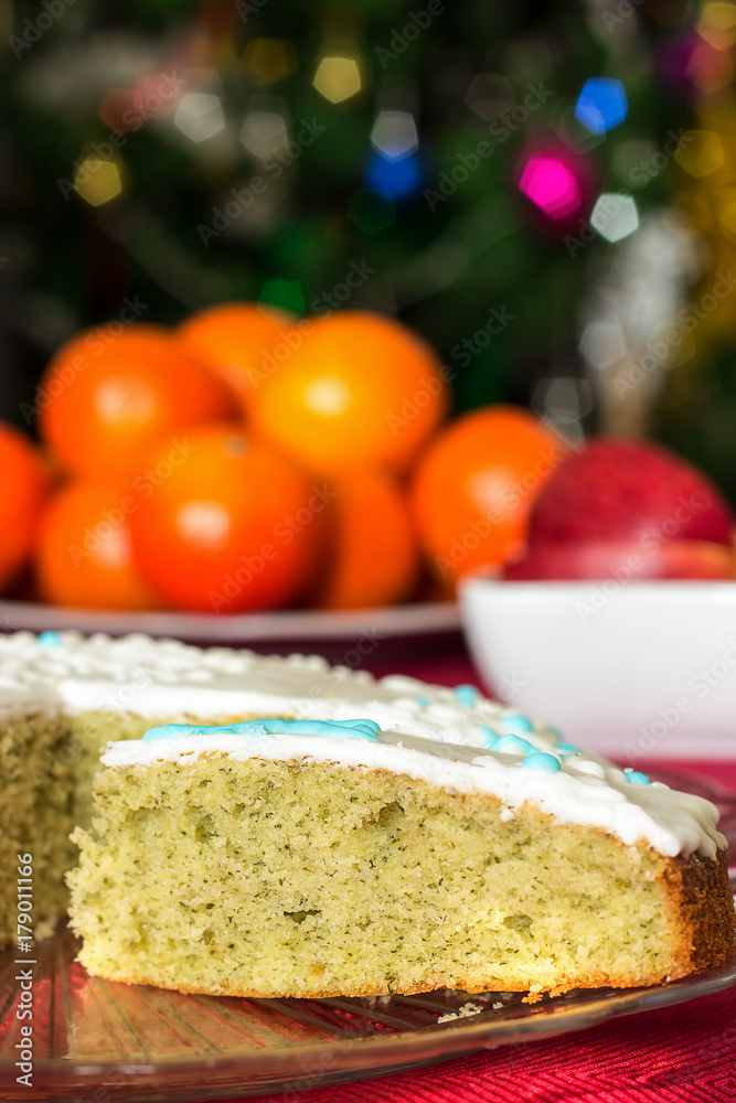 Delicious homemade sponge cake with mint. Christmas concept. Blurred New Year's background tangerines, lights. Selective focus. Delicious homemade sponge cake with mint. Christmas concept. Blurred New Year's background tangerines, lights. Selective focus.