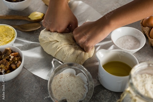 Woman preparing dough surrounded with various ingredients