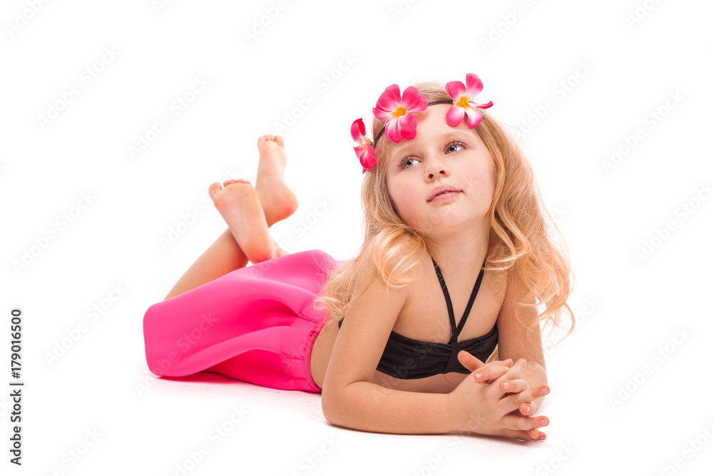 Attractive little girl in black bikini, pink skirt and pink wreath, lies Attractive little girl in black bikini, pink skirt and pink wreath, lies