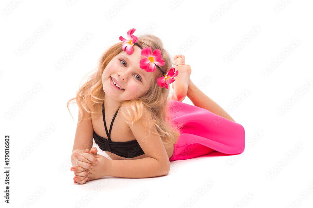 Attractive little girl in black bikini, pink skirt and pink wreath, lies Attractive little girl in black bikini, pink skirt and pink wreath, lies