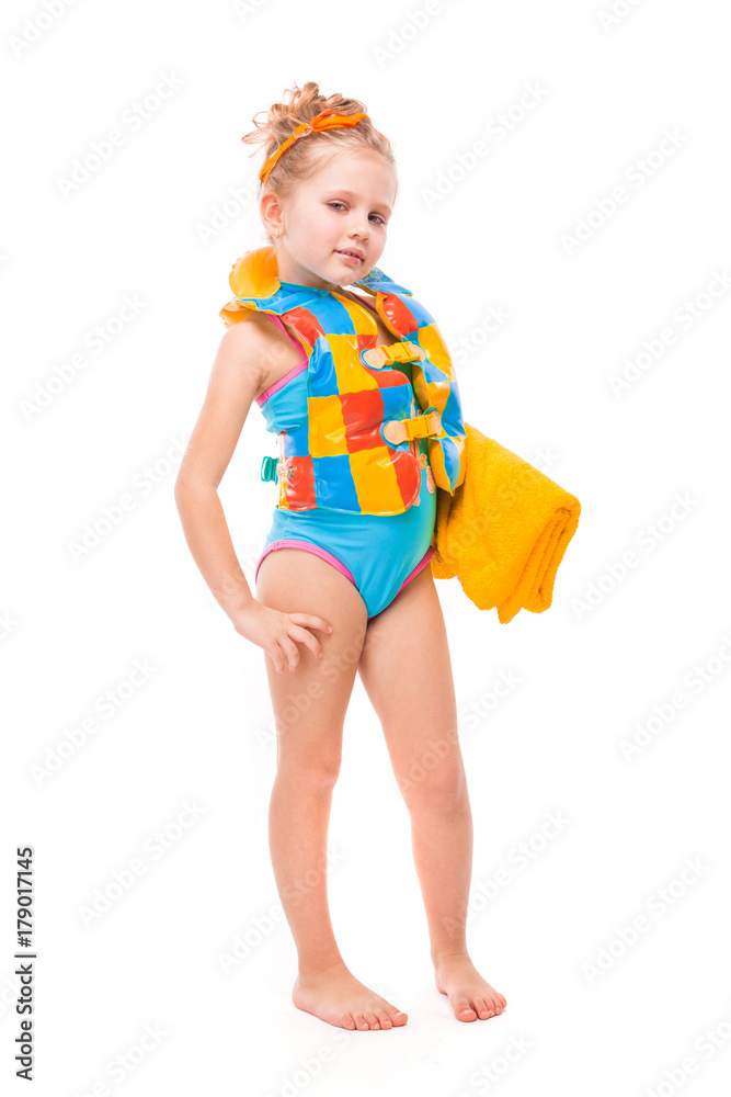 Pretty cute little girl in in blue swimming suit and colorful life jacket hold yellow towel Pretty cute little girl in in blue swimming suit and colorful life jacket hold yellow towel