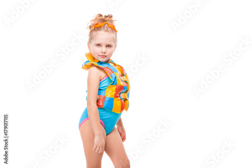 Beautiful little girl in in blue swimming suit and colorful life jacket
